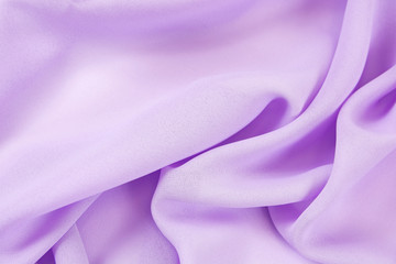 The texture of the satin fabric of lilac color for the background