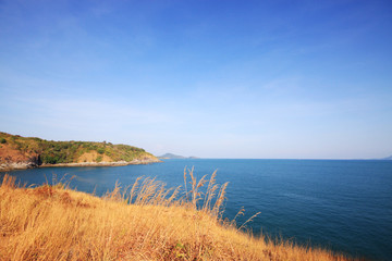 Fototapeta na wymiar Beautiful seascape with sky twilight of sunset and sea horizon with Calm and blue sky.Dry grass field on mountain of Phrom Thep Cape is famous place in Phuket island, Thailand.
