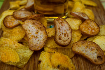 Beer in a glass with chips and breadcrumbs. In a glass goblet.