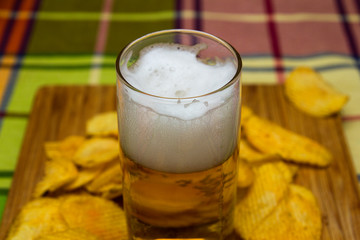 Beer in a glass with chips and breadcrumbs.