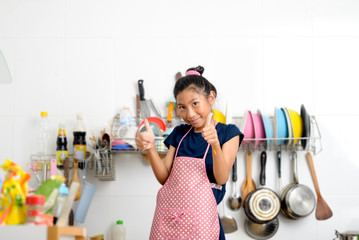 Happy Asian girl thumbs up after finished dish washing, duty housework lifestyle.