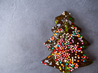 colorful lollipop in the form of Christmas tree on a concrete board. Celebratory background.