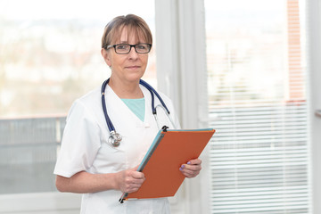 Portrait of  doctor standing and holding a folder