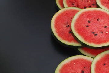 Watermelon slices on black table with copyspace