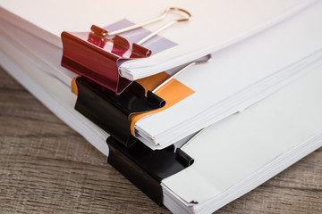 Stacks of piles unfinished papers documents files in accounting business report with black clips paper corner on desk in busy office, Paperwork of financial folder at business workplace concept