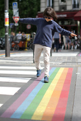 Young careful child crossing the street with fun, city background