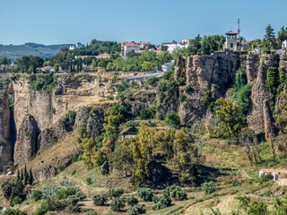 Fototapeta na wymiar Ronda, Spain: Landscape of white houses on the green edges of steep cliffs.