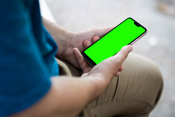 close up handsome man use left hand typing mobile phones and touch screen working with app devices in park