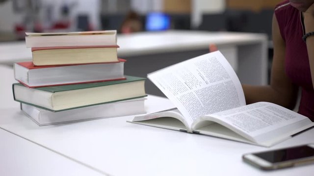Girl studying in books at library table 4k