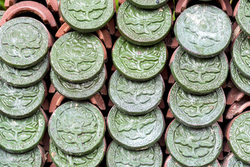 Green embossed flower ceramic pattern on roof tiles.