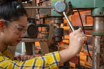 Women standing is craft working drill wood
