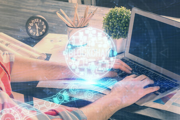 Crypto currency theme hologram with businessman working on computer on background. Concept of...