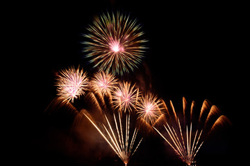 Beautiful colorful fireworks display on the urban lake for celebration on dark night background....