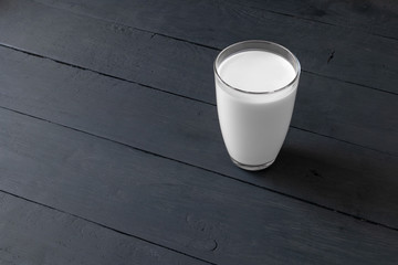 glass of milk on a dark wooden table