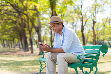 Asian man using smartphone in park