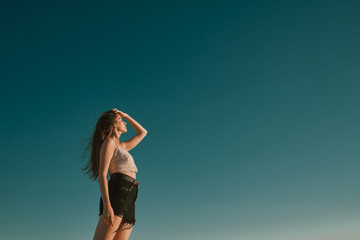 Fototapeta premium a young woman in a summer day with a blue sky - negative space