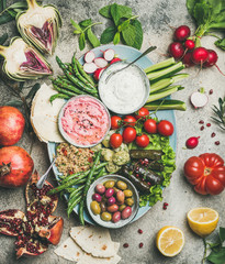 Vegetarian snack board. Flat-lay of beetroot hummus, yogurt dip, kinoa salad, olives, beens,...