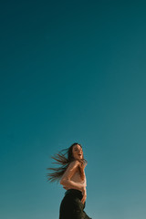 a young woman in a summer day with a blue sky - negative space