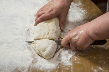 Obraz premium Hands kneading dough for gnocchi.