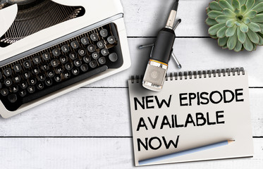 podcast concept, top view of microphone on desk with old typewriter and notepad with text NEW...