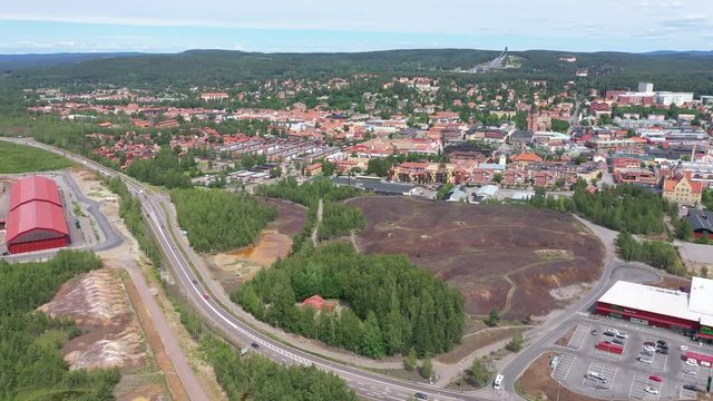 Drone footage flying towards a large slag heap from Falu copper mine. The city center of Falun and the ski jumping area - Lugnet - is visible in the background. Filmed in realtime at 4k.