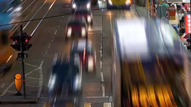 Taxi cabs, double deck buses, trams crossing a crossroad in the central district. People fast walking pedestrian crossing Center of Hong Kong Island