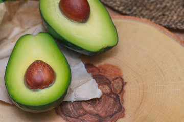 Avocado on a wooden Board with the spinach leaves. Fresh avocado sliced on vintage wooden...