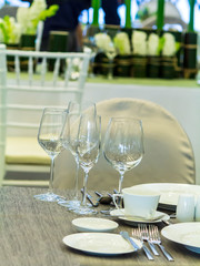 Luxury party dinner table setting with tableware and silverware and glasses set and Candlestick and flower in restaurant.