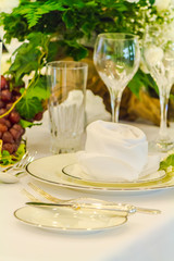 Luxury party dinner table setting with tableware and silverware and glasses set and Candlestick and flower in restaurant.