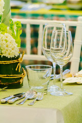 Luxury party dinner table setting with tableware and silverware and glasses set and Candlestick and flower in restaurant.