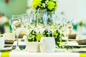 Luxury party dinner table setting with tableware and silverware and glasses set and Candlestick and flower in restaurant.