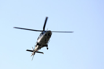 Fototapeta na wymiar Beautiful modern helicopter in flight isolated against sky
