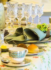 Luxury party dinner table setting with tableware and silverware and glasses set and Candlestick and flower in restaurant.