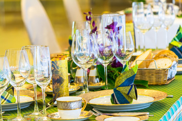 Wedding party dinner table setting with tableware and silverware and glasses set and Candlestick and flower in restaurant.