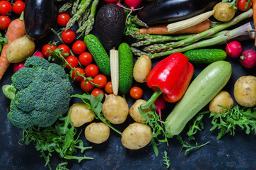 top view portrait of Assortment of fresh raw vegetables on black wooden background.