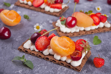 Crisp bread with creme cheese, fruit and berries