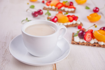 Cup of tea and crisp bread with creme cheese, fruit and berries