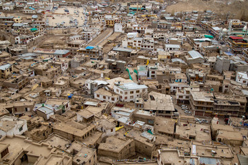 Leh Ladakh city view from Leh Palace on winter. Beautiful amazing village in the valley with snow mountain at background. Ladakh, India.