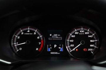close up modern mileage car dashboard instrument panel interior with warning lights, seat belts and handbrake lights. Miles Speedometer 