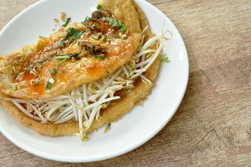 fried egg stuffed mussel with bean sprout topping garlic and dressing chili sauce on plate