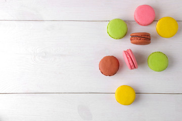 macaroons. delicious colored french macaroni cakes on a white wooden table. place for text. top view