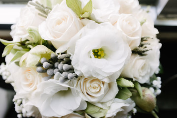 White bouquet of flowers standing in a vase on the window
