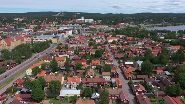 Ascending drone footage flying over the city of Falun. In the background the ski jumping area - Lugnet - is visible and on the right hand side the lake Runn is visible. Filmed in realtime at 4k.