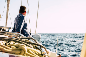 Free man enjoying outdoor leisure activity on a sail boat with blue ocean around - luxury summer holiday vacation concept - Happy people sailing with nature and nice weather