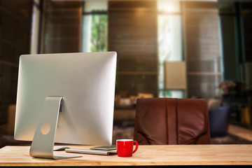 workspace with computer, laptop, office supplies, and coffee cup, smartphone, and tablet at office. desk work concept. in morning light