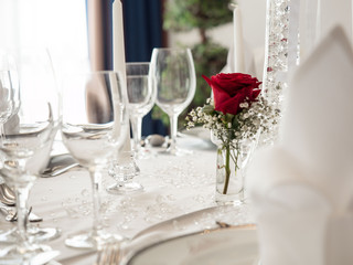 wedding table. noble wine glasses and roses decorating white clean table