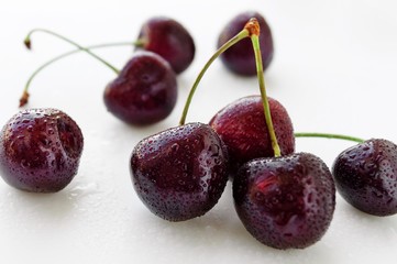 Fresh cherry berries with water drops on white background. Selective focus.