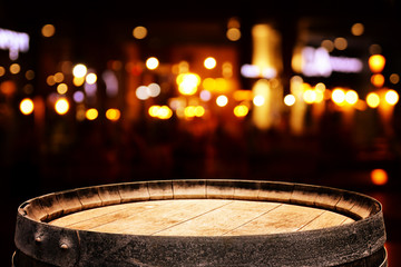 background of wooden barrel in front of abstract blurred restaurant lights