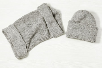 Handmade knitted clothing, woolen hat and soft snood. Warm things for winter season. Top view. Copy space. Flat lay.