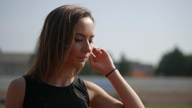Young girl athletic runner looks into the camera. A beautiful matchmaker smiles.